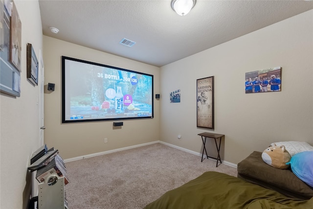 home theater room featuring a textured ceiling and light carpet