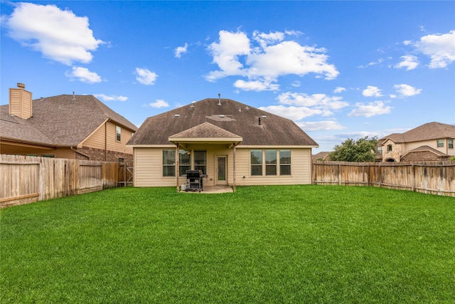 back of house with a patio area and a yard