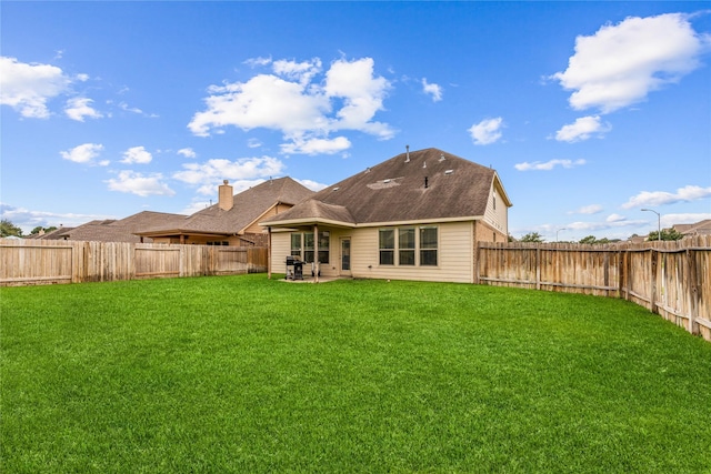 rear view of property with a patio and a lawn