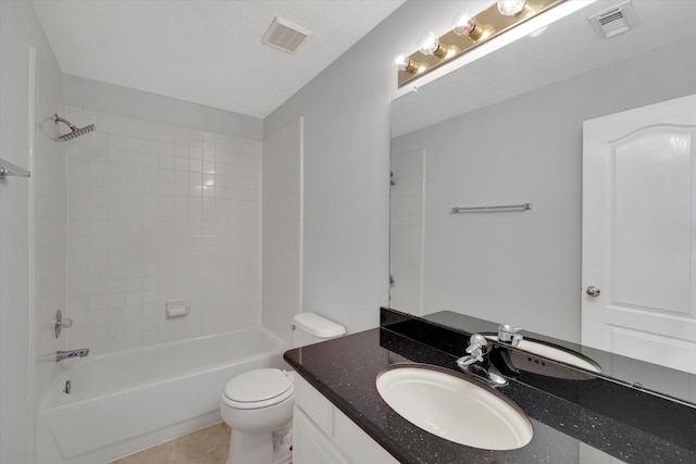 full bathroom featuring tile patterned floors, vanity, tiled shower / bath combo, and toilet