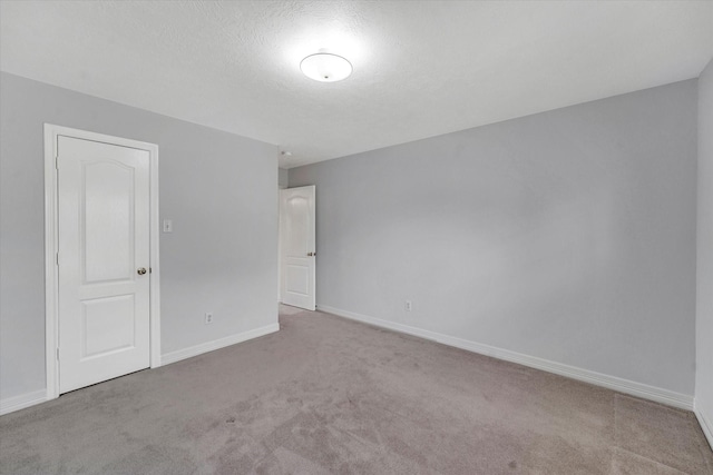 unfurnished room with light carpet and a textured ceiling