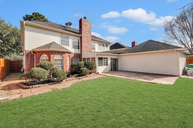 rear view of house featuring a lawn and a patio