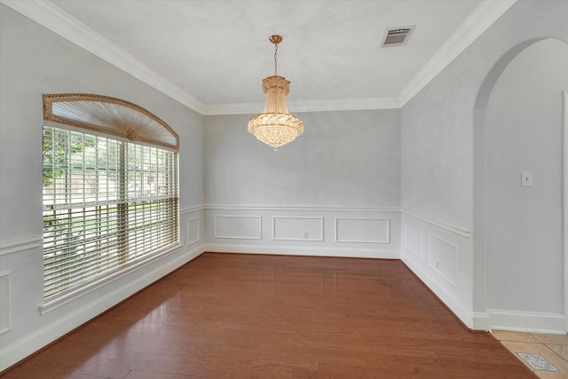 unfurnished room with crown molding and a notable chandelier