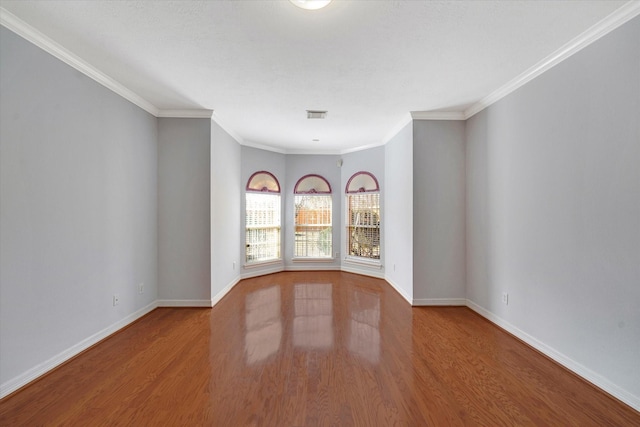 spare room featuring wood-type flooring and ornamental molding