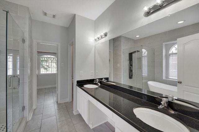 bathroom featuring plus walk in shower, vanity, and tile patterned flooring