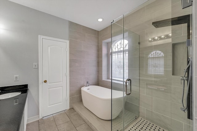 bathroom with tile patterned flooring, vanity, separate shower and tub, and tile walls