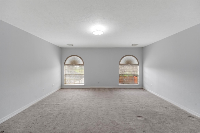 carpeted empty room with a textured ceiling