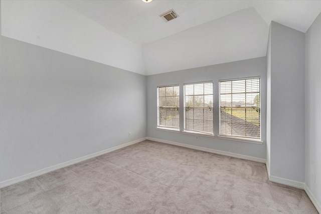 carpeted spare room with vaulted ceiling