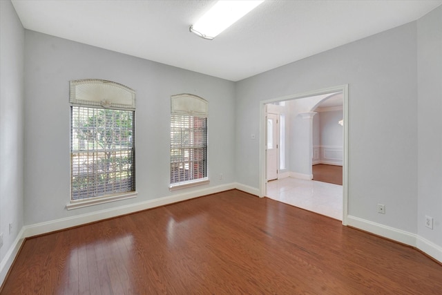 spare room with ornate columns and hardwood / wood-style floors