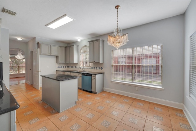 kitchen featuring sink, a kitchen island, an inviting chandelier, stainless steel dishwasher, and light tile patterned flooring