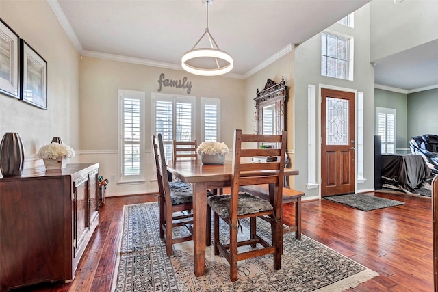 dining space featuring crown molding and dark wood-type flooring