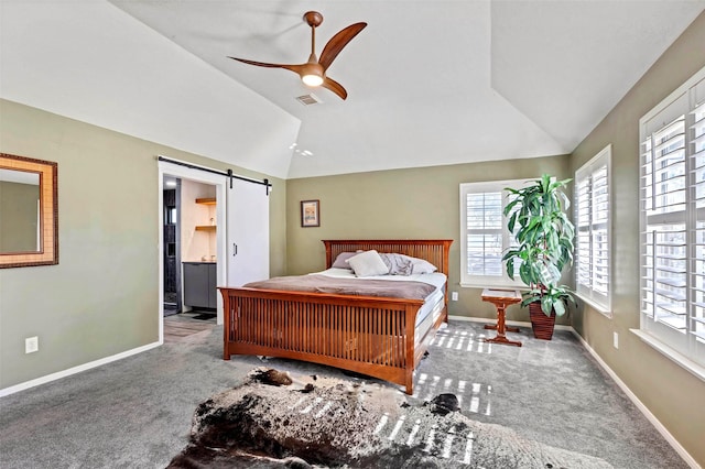 carpeted bedroom featuring connected bathroom, ceiling fan, a barn door, lofted ceiling, and multiple windows