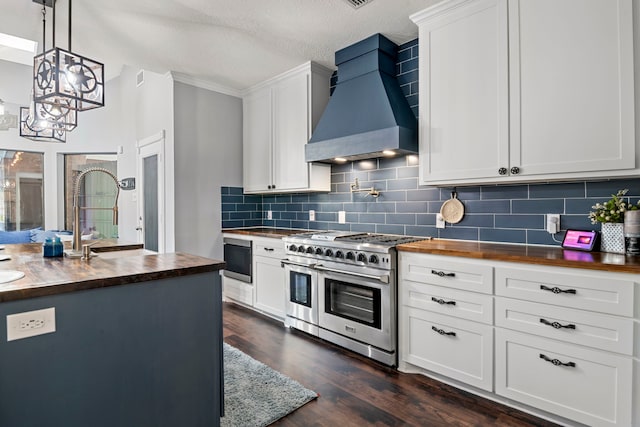 kitchen with white cabinets, wood counters, range with two ovens, premium range hood, and backsplash