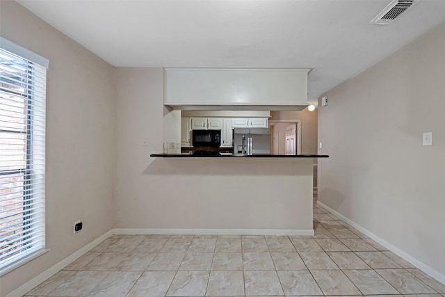 kitchen featuring stainless steel fridge and kitchen peninsula