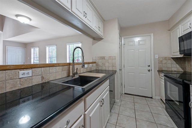 kitchen featuring black appliances, sink, tasteful backsplash, light tile patterned flooring, and white cabinetry