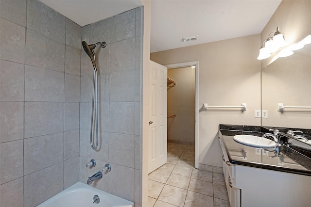 bathroom featuring vanity and tiled shower / bath