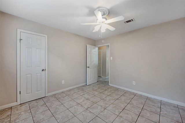 empty room featuring light tile patterned floors and ceiling fan