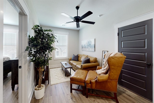 sitting room with hardwood / wood-style floors and ceiling fan