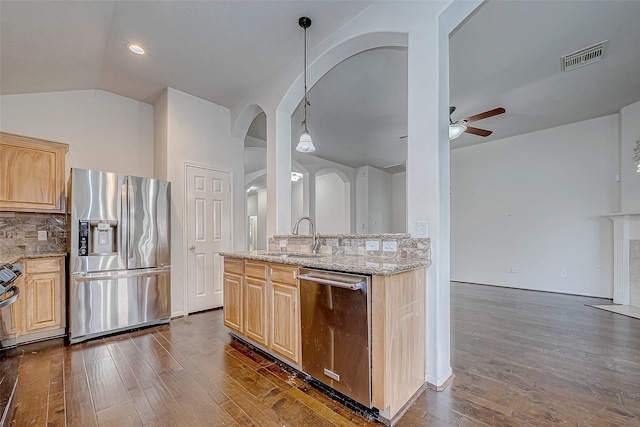 kitchen with decorative backsplash, appliances with stainless steel finishes, sink, light brown cabinets, and pendant lighting