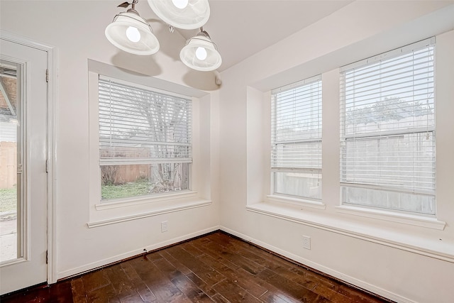 unfurnished dining area with dark wood-type flooring