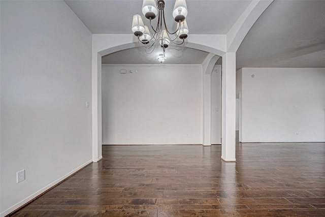 unfurnished dining area featuring a notable chandelier and dark hardwood / wood-style flooring