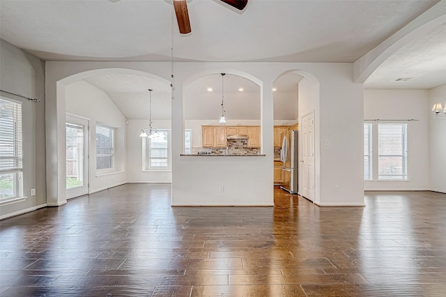 unfurnished living room with dark hardwood / wood-style flooring and ceiling fan with notable chandelier