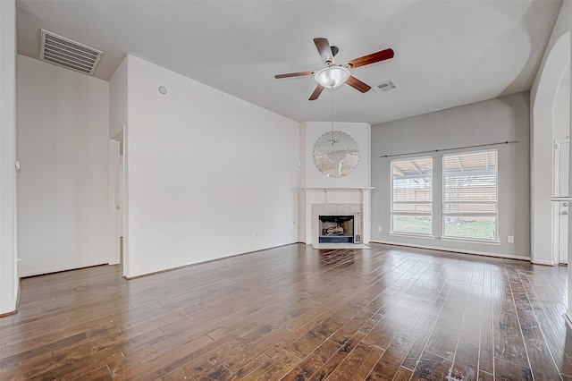 unfurnished living room with hardwood / wood-style floors, ceiling fan, and a tiled fireplace