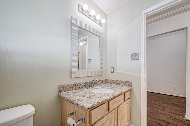 bathroom featuring hardwood / wood-style floors, vanity, and toilet