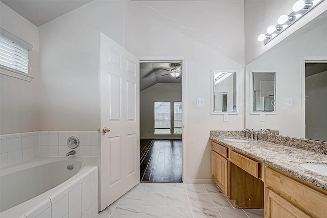 bathroom featuring vanity, a relaxing tiled tub, ceiling fan, and lofted ceiling