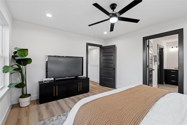 bedroom featuring connected bathroom, light hardwood / wood-style floors, and ceiling fan