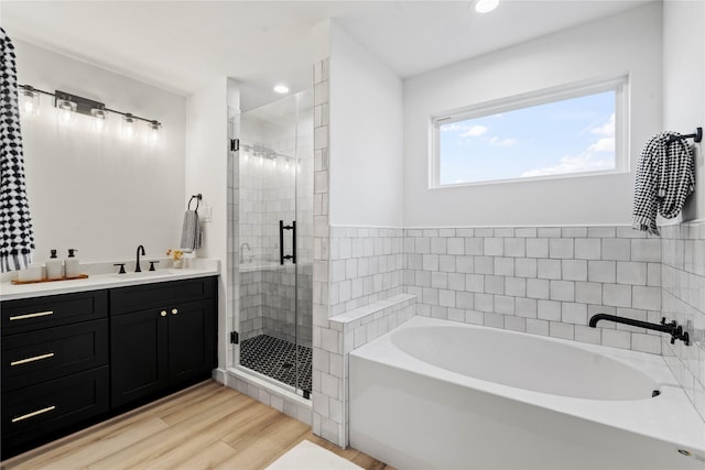 bathroom with vanity, hardwood / wood-style flooring, and independent shower and bath