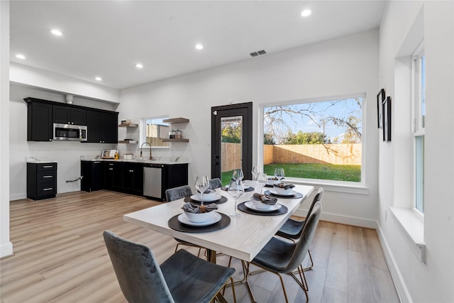 dining space featuring light wood-type flooring and sink