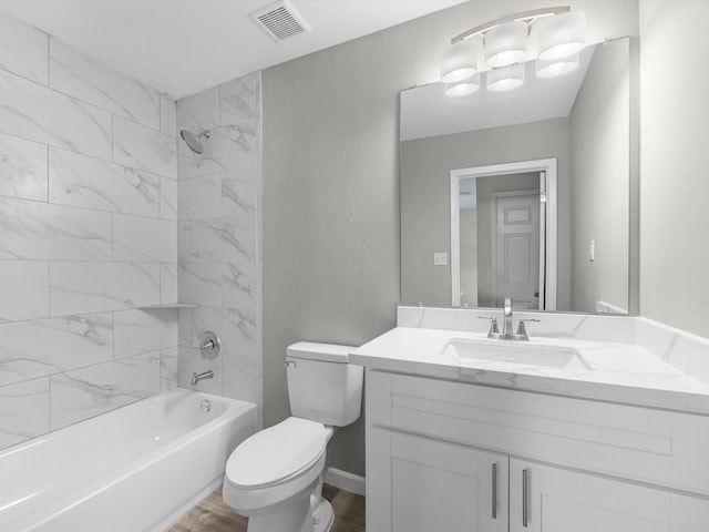 full bathroom featuring hardwood / wood-style floors, vanity, toilet, and tiled shower / bath