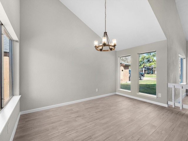 spare room with high vaulted ceiling and a notable chandelier