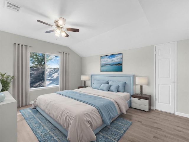 bedroom featuring ceiling fan, light hardwood / wood-style flooring, and lofted ceiling