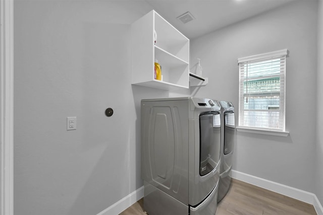 laundry area featuring light hardwood / wood-style floors and washing machine and dryer