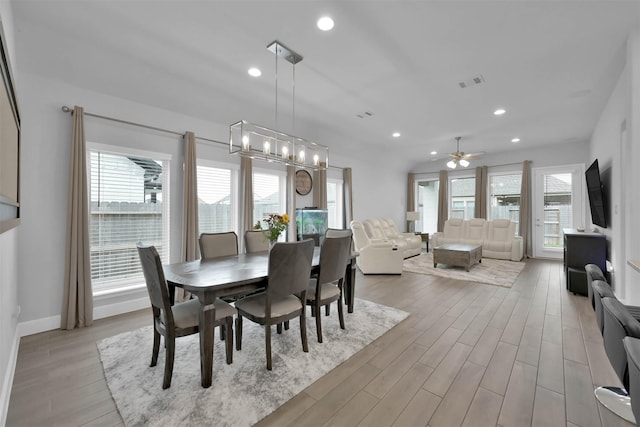 dining space with plenty of natural light and ceiling fan with notable chandelier