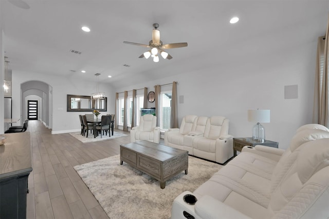 living room with light hardwood / wood-style floors and ceiling fan with notable chandelier