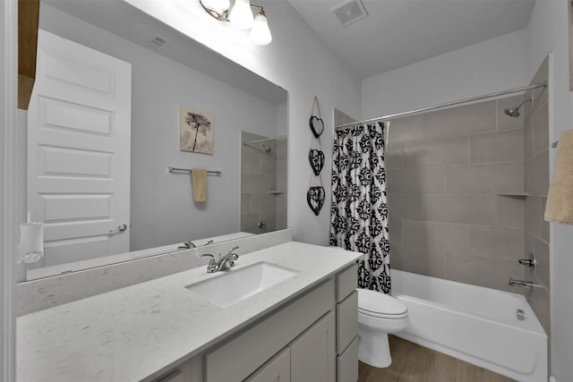 full bathroom with hardwood / wood-style floors, vanity, shower / bath combination with curtain, and toilet