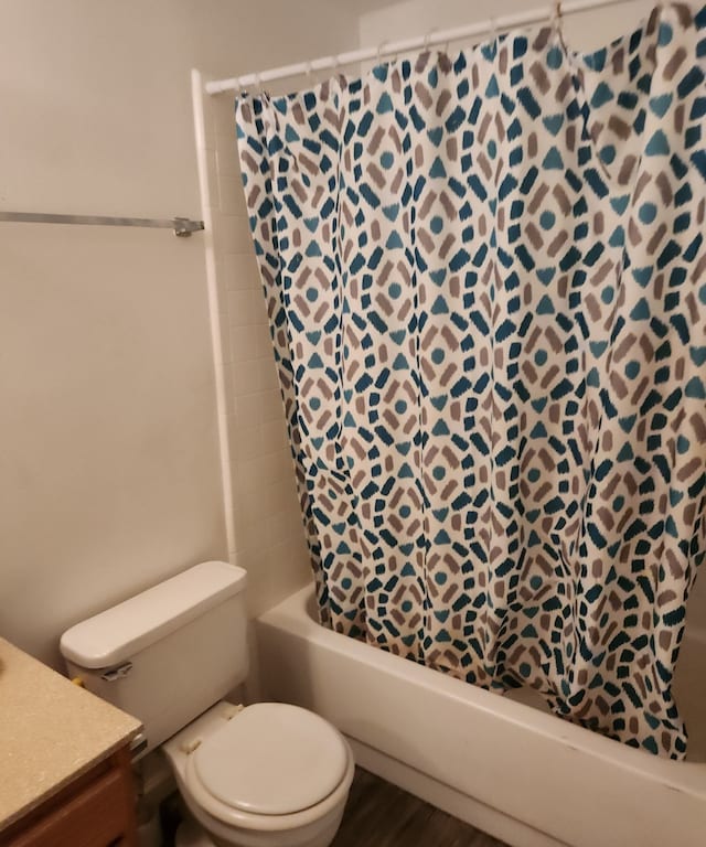 full bathroom with vanity, hardwood / wood-style floors, shower / bath combo with shower curtain, and toilet