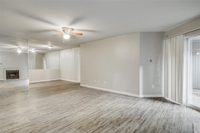 9797 Leawood Blvd Unit 903, Houston, TX 77099 - unfurnished living room featuring ceiling fan, wood finished floors, a fireplace, and baseboards