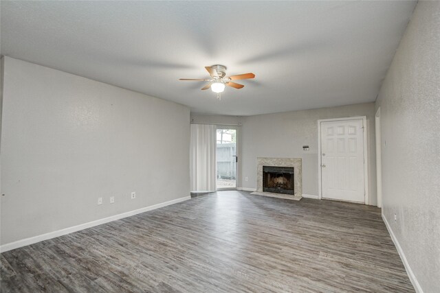9797 Leawood Blvd Unit 903, Houston, TX 77099 - unfurnished living room with ceiling fan, wood finished floors, a high end fireplace, baseboards, and a textured wall