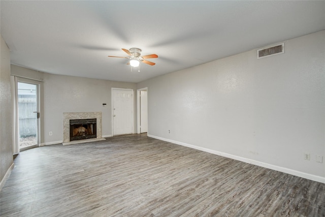 9797 Leawood Blvd Unit 903, Houston, TX 77099 - unfurnished living room with wood finished floors, a ceiling fan, a high end fireplace, and baseboards