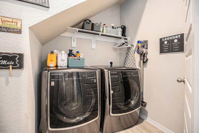 laundry area with separate washer and dryer and hardwood / wood-style floors