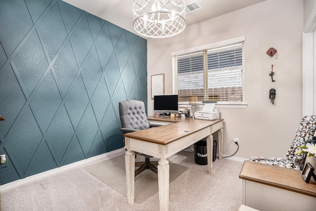 carpeted home office with a chandelier