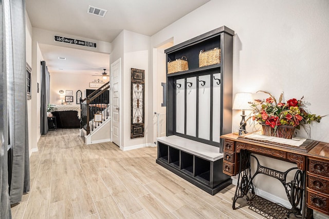 mudroom with light wood-style floors, baseboards, visible vents, and a ceiling fan