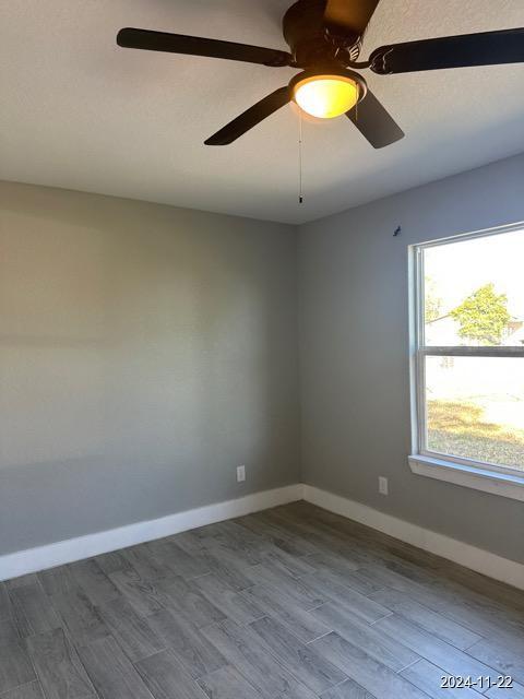 unfurnished room featuring ceiling fan and hardwood / wood-style floors