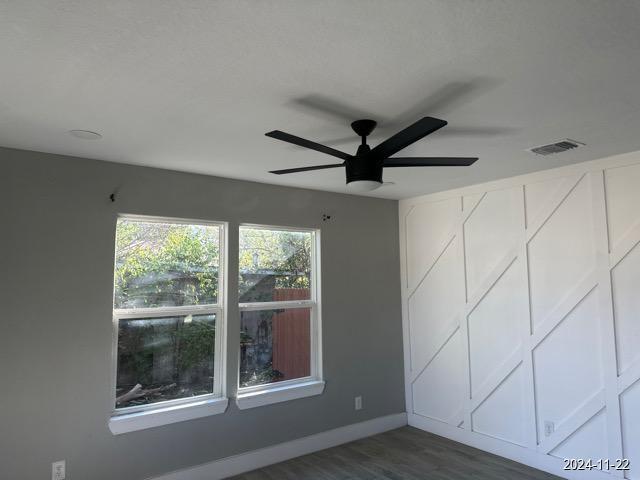 unfurnished room featuring ceiling fan and dark hardwood / wood-style floors