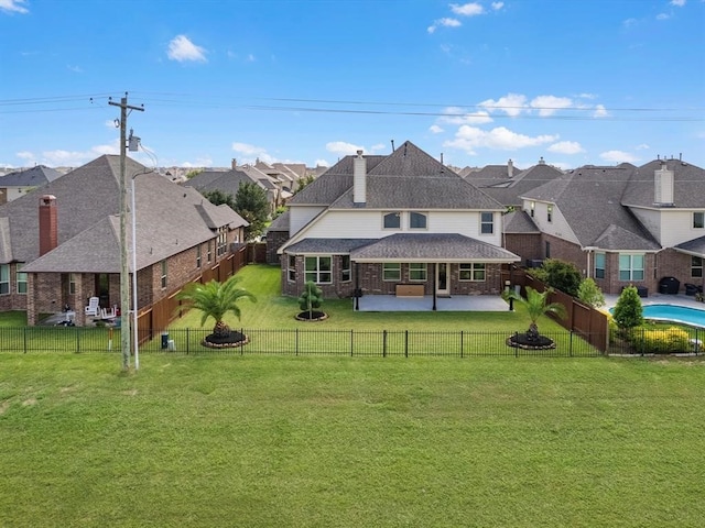 back of property with a yard and a patio area