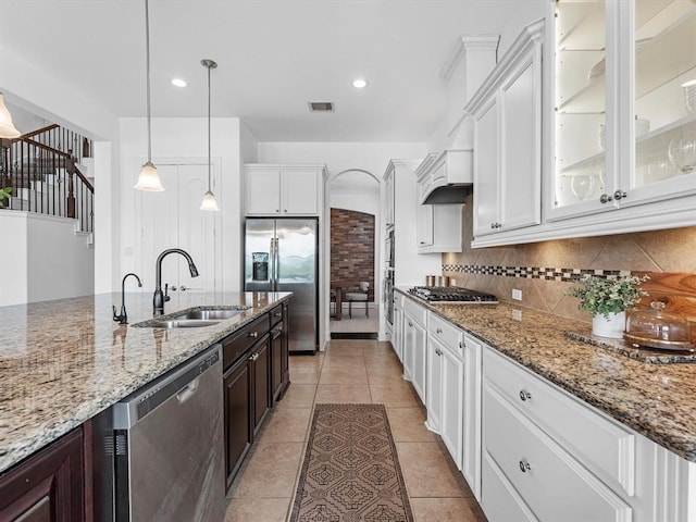 kitchen featuring decorative light fixtures, sink, white cabinets, appliances with stainless steel finishes, and dark brown cabinetry